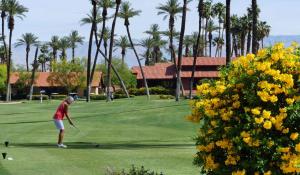 a man is playing golf on a golf course at Spectacular View Just Steps to Pool and Jacuzzi at Sunrise Country Club in Rancho Mirage