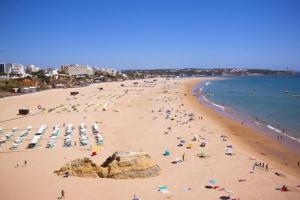 a beach with a lot of people and the ocean at On Apulia Beach 4 PAX Suite Room in Apúlia