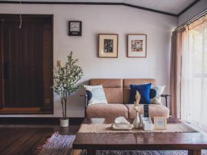 a living room with a couch and a coffee table at 最大8名 庭園に住むアート Active Art Hotel 80畳の広さを誇る古民家 日本庭園を独り占め in Sado