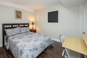Newly Renovated 3BR Orangeville Basement Suite with Private Access, 10 Min Walk to Headwaters Hospital, 5 Min Drive to Mount Alverno! Ideal for Medical Stay, Family Travel & Work Trips! في أورنجفيل: غرفة نوم بها سرير مع لحاف أزرق وأبيض