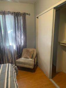 パサデナにあるBACK HOUSE in PASADENAのベッドと椅子と窓のある寝室