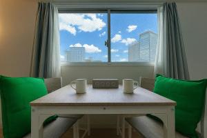 a dining room table with two chairs and a window at TOEI BUSSAN Building20 in Osaka
