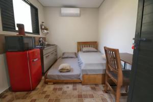 a small kitchen with two twin beds and a tv at Estúdio VI - Franco da Rocha in Franco da Rocha