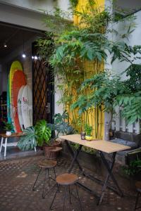 a table and chairs in a room with plants at SŨRF DÔM Vungtau - surf camp coliving in Vung Tau
