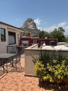 a patio with a table and chairs and a mountain at Hotel del Centro in Bernal
