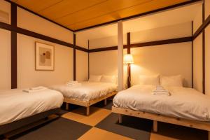 a room with two beds and a lamp at J style villa Sapporo フルリフォーム 長期滞在にもオススメ マーケット近く in Sapporo