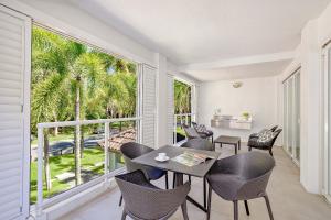 a dining room with a table and chairs and a large window at Peppers Beach Club in Port Douglas