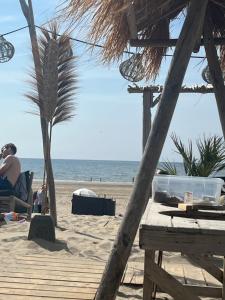 a man sitting in a chair on the beach at Zandvoort Boutique Apartments in Zandvoort