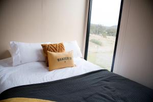 Doyles CreekBundaleer Tiny House 2 by Tiny Away的一张带枕头的床和窗户