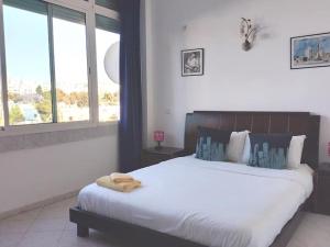 Un dormitorio con una cama grande y una ventana grande en 8 agdal, en Rabat