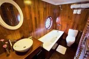 a bathroom with a sink and a tub and a toilet at Le Journey 4-Star Halong Cruise in Ha Long