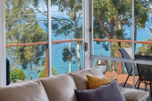 a living room with a couch and a large window at Little Roaring Beach Shack in Dover