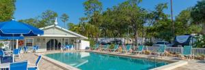 a swimming pool with chairs and umbrellas at Sun RV in Trailer park in Naples