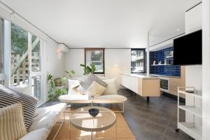a living room with a couch and a table at The Hastings Beach Houses in Noosa Heads