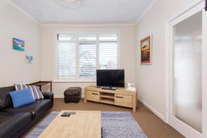 a living room with a couch and a flat screen tv at Living the Dream - 3 bedroom House South Fremantle in South Fremantle