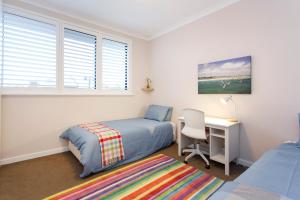 a bedroom with a bed and a desk with a chair at Living the Dream - 3 bedroom House South Fremantle in South Fremantle +31 photos