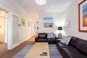 a living room with a leather couch and a coffee table at Living the Dream - 3 bedroom House South Fremantle in South Fremantle