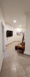 a living room with a couch and a tv on a wall at La Sierra Departamento 1 in Ciudad Juarez
