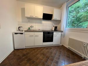 a small kitchen with white appliances and a window at Stay 15 Kassel in Kassel