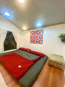 a bedroom with a large bed with a red blanket at RoBin's Home in Da Thanh