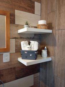 a wall with white shelves on it with towels at Prunus departamentos in Comodoro Rivadavia
