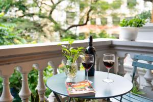 a table with a bottle of wine and two glasses at Picturesque Hanoi Homestay in Hanoi