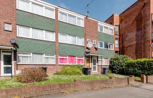 Private Beautiful Cozy Double Bedroom in London في South Norwood: مبنى أخضر بأبواب حمراء في الشارع