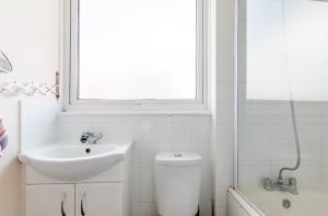 Private Beautiful Cozy Double Bedroom in London في South Norwood: حمام مع حوض ومرحاض ونافذة +8 صور