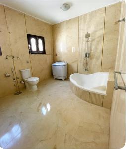 a bathroom with a tub and a toilet and a sink at Cairo Airport Retreat - Stylish Stay, Obour city -First district in Obour
