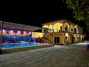 a building with a swimming pool at night at Apartamento Hotel Alfa y Omega in San Benito