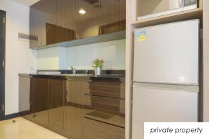 a kitchen with a refrigerator and a sink at Warm Aston Bellevue HOTEL Apartment - SMART TV in Jakarta +7 photos