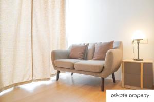 a chair in a living room with a window at Warm Aston Bellevue HOTEL Apartment - SMART TV in Jakarta