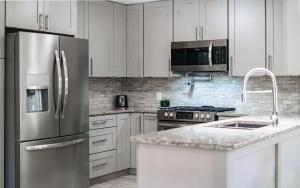 a kitchen with white cabinets and a stainless steel refrigerator at Cottage On The Ridge in Sevierville +9 photos