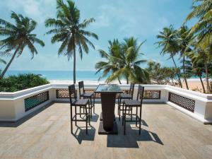 a balcony with a table and chairs and the beach at Villa 46 in Hikkaduwa