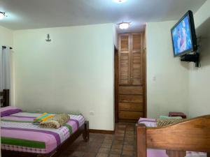 a bedroom with two beds and a tv on the wall at Villa Vacacional Los Cayos in Boca de Aroa +11 photos