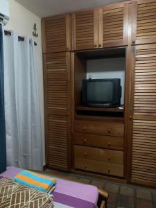 a living room with a tv and a dresser at Villa Vacacional Los Cayos in Boca de Aroa