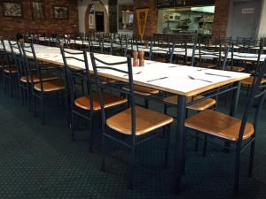 a long wooden table and chairs in a restaurant at Corryong Hotel Motel in Corryong