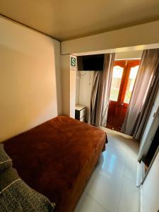 a small bedroom with a bed and a window at Huamanga plaza in Ayacucho