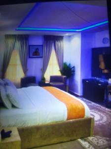 a bedroom with a large bed and two windows at Morgan Hill Residence in Abuja