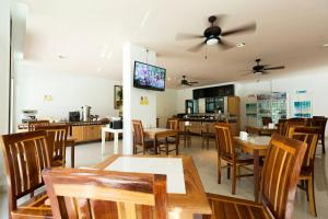 a dining room with tables and chairs and a kitchen at Neo Hotel in Jomtien Beach +20 photos