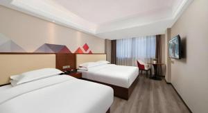 a hotel room with two beds and a desk at Borrman Hotel Guangzhou Railway Station Sanyuanli Metro Station in Guangzhou +121 photos