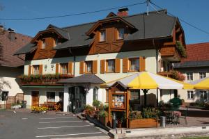 un grand bâtiment avec un magasin devant lui dans l'établissement Pension Oberjörg, à Rattendorf