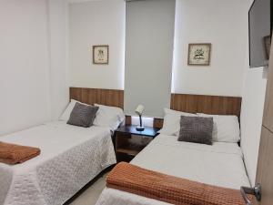 a bedroom with two beds and a night stand with twoitures at Un lugar especial en San Salvador in San Salvador