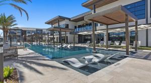 a swimming pool with lounge chairs in front of a building at Landing at La Tierna - San Antonio Northwest Side in San Antonio