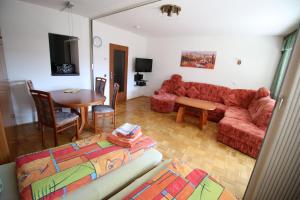 un soggiorno con divano rosso e tavolo di FeWo-Winterberg a Winterberg