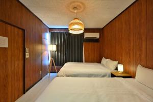 Una habitación de hotel con dos camas y una lámpara de araña. en Castle Land NAGOYA, en Nagoya