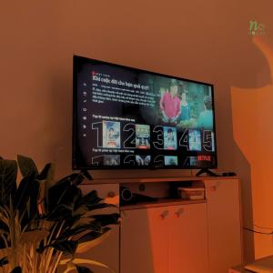 a flat screen tv sitting on top of a cabinet at Nạ House - Homestay Đất Cảng in Hai Phong