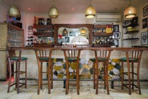 a bar with wooden stools in a room at Hotel Brajas in Antananarivo