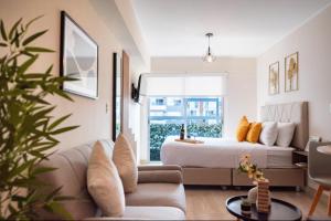 a bedroom with a bed and a living room with a couch at G15 Apartments by Vibrant in Lima