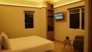 a bedroom with a bed and a flat screen tv at Hotel Cikini in Jakarta